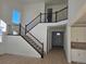 Open foyer with hardwood floors, staircase with dark railing, and natural light from a window at 5685 Farrier Pt, Castle Rock, CO 80104