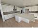 Bright kitchen with white cabinets, a large center island with a stone countertop, and wood floors at 5685 Farrier Pt, Castle Rock, CO 80104