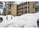 Exterior of a condo building with snow-covered parking lot in foreground at 1173 Ski Hill Rd # 127, Breckenridge, CO 80424