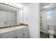 Bathroom featuring updated vanity, mosaic tile accents, and a separate toilet area with window for added privacy at 7863 Windfont Row, Parker, CO 80134
