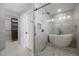 Bright bathroom featuring sleek glass shower, modern soaking tub, stylish tiling, and access to the walk-in closet at 7863 Windfont Row, Parker, CO 80134