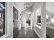 Inviting entryway with modern light fixture, wood floors, and an open view into the spacious interior of the home at 7863 Windfont Row, Parker, CO 80134