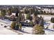 Two-story home with covered balcony, dark exterior paint, surrounded by mature trees and snow covered grounds at 7863 Windfont Row, Parker, CO 80134