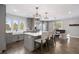 Open concept kitchen with island seating, stainless steel appliances, and seamless flow to the living space at 7863 Windfont Row, Parker, CO 80134