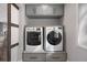 A practical laundry area with a front-load washer and dryer set and ample storage at 7863 Windfont Row, Parker, CO 80134