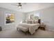 Comfortable main bedroom with neutral tones, two windows, ceiling fan and modern decor at 7863 Windfont Row, Parker, CO 80134