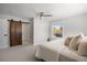Comfortable main bedroom featuring a rustic sliding barn door and scenic views at 7863 Windfont Row, Parker, CO 80134