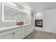 Bright bathroom boasts a double vanity with an illuminated mirror and fireplace at 618 Fairchild Dr, Highlands Ranch, CO 80126