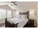 Cozy bedroom boasts large windows, a dark wood bed frame and hardwood floors at 618 Fairchild Dr, Highlands Ranch, CO 80126