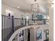 Open foyer showcases a multi-tiered chandelier, dark hardwood floors, and railing at 618 Fairchild Dr, Highlands Ranch, CO 80126