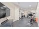 Home gym with various exercise equipment, a large TV, and a padded floor for fitness enthusiasts at 618 Fairchild Dr, Highlands Ranch, CO 80126