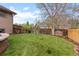 Lush backyard with a well-maintained lawn, wooden fence, and cozy fire pit area perfect for outdoor enjoyment at 12017 W Cross Dr, Littleton, CO 80127