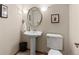 Charming powder room featuring pedestal sink, round mirror, and modern fixtures for guests at 12017 W Cross Dr, Littleton, CO 80127