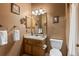 Cozy bathroom featuring a single vanity, mirror, and toilet at 12017 W Cross Dr, Littleton, CO 80127