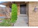 Home's front door is accessed by concrete steps from the driveway and landscaped yard at 12017 W Cross Dr, Littleton, CO 80127