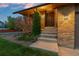 Home's front door is accessed by concrete steps from the driveway and landscaped yard at 12017 W Cross Dr, Littleton, CO 80127