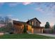 Beautiful two-story home with well-kept lawn and two-car garage in the evening at 12017 W Cross Dr, Littleton, CO 80127