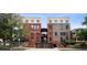 Apartment building with brick facade, exterior stairwell, and ground-level garage showcasing urban living at 790 N Clarkson St # 206, Denver, CO 80218