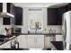 Modern kitchen featuring stainless steel appliances, black and white cabinetry, and a window overlooking the exterior at 790 N Clarkson St # 206, Denver, CO 80218