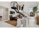 Spacious living room with modern staircase, white walls, large windows, art, and zebra bench at 790 N Clarkson St # 206, Denver, CO 80218