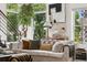 Bright living room featuring a comfortable sofa, art, large windows and a leafy green tree at 790 N Clarkson St # 206, Denver, CO 80218