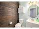 Powder room featuring rustic wood wall, vanity, and commode at 5475 Shoshone Dr, Longmont, CO 80504