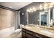 Stylish bathroom features a double sink vanity, a bathtub with a shower, and modern neutral finishes at 5475 Shoshone Dr, Longmont, CO 80504