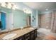Well-lit bathroom featuring double sinks with granite counters, a shower-tub combo, and modern fixtures at 5475 Shoshone Dr, Longmont, CO 80504