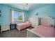 Bright, cheery bedroom with two twin beds, soft blue walls, and a large window offering outdoor views at 5475 Shoshone Dr, Longmont, CO 80504