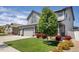 View of home's front yard with a lush lawn and mature landscaping at 5475 Shoshone Dr, Longmont, CO 80504