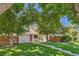 Beautiful home featuring a lush green lawn, mature trees, and a charming red front door at 2896 W 119Th Ave, Westminster, CO 80234