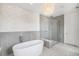 Bright modern bathroom with stone accent wall, freestanding tub, glass enclosed shower, and chandelier at 7033 E Lake Cir, Centennial, CO 80111