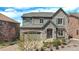 Beautiful two-story home with stone accents, gray siding, a gray roof, and manicured landscaping at 7033 E Lake Cir, Centennial, CO 80111