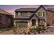 Beautiful two-story home with stone accents, gray siding, a gray roof, and manicured landscaping at 7033 E Lake Cir, Centennial, CO 80111
