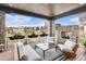 Cozy covered deck featuring a stone fireplace, ample seating, and planters with views of the neighborhood at 7033 E Lake Cir, Centennial, CO 80111