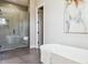 This bathroom features a glass enclosed shower with bench and freestanding tub at 7778 Windwood Way, Parker, CO 80134
