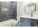 Modern bathroom featuring sleek vanity with dark hardware and a stylish tiled shower over tub at 7778 Windwood Way, Parker, CO 80134