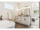 Luxurious bathroom with a soaking tub, double vanity, and modern fixtures at 7778 Windwood Way, Parker, CO 80134