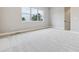 A spacious bedroom features neutral carpeting, a window, and a gray door at 7778 Windwood Way, Parker, CO 80134