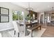 Elegant dining room with a modern chandelier and a large window overlooking lush greenery at 7778 Windwood Way, Parker, CO 80134