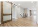 Open entryway features wood floors, a sliding barn door, and a staircase with rod iron railing at 7778 Windwood Way, Parker, CO 80134