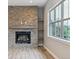 The living room features a brick fireplace with custom shelving, a large window, and wood floors at 7778 Windwood Way, Parker, CO 80134