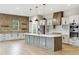 The kitchen features modern appliances, quartz countertops, a large island, and a brick accent wall at 7778 Windwood Way, Parker, CO 80134