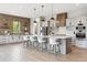 Spacious kitchen with large island, barstool seating, modern appliances, and beautiful pendant lighting at 7778 Windwood Way, Parker, CO 80134