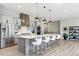 Open-concept kitchen with island seating, stainless steel appliances, and stylish pendant lighting at 7778 Windwood Way, Parker, CO 80134