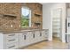 This kitchen features white cabinets with black hardware, floating shelves, and a walk-in pantry at 7778 Windwood Way, Parker, CO 80134