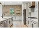 Modern kitchen features white cabinets, stainless steel appliances, brick accents, and sleek countertops at 7778 Windwood Way, Parker, CO 80134
