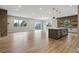 Spacious open-concept kitchen features an island, hardwood floors, brick wall, and tons of natural light at 7778 Windwood Way, Parker, CO 80134