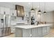 This kitchen features an island with pendant lights, sleek appliances, and white subway tile backsplash at 7778 Windwood Way, Parker, CO 80134