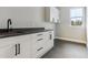 Laundry room features modern white cabinets, a dark countertop, and tile floors at 7778 Windwood Way, Parker, CO 80134